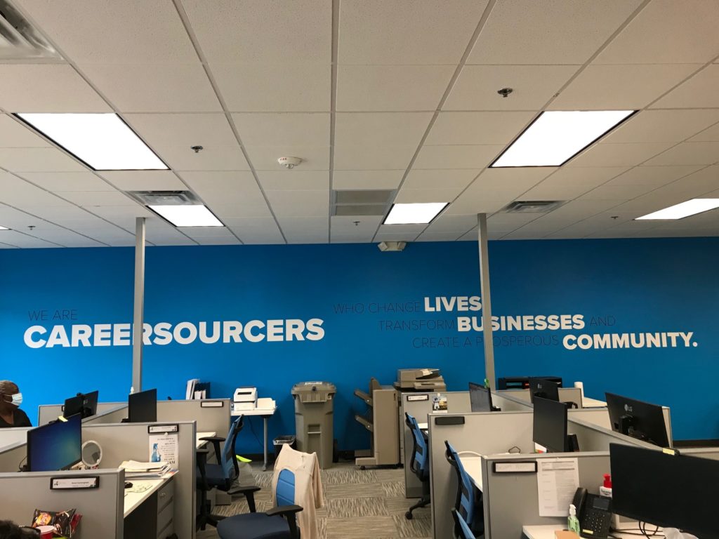 Blue wall, office cubicles with computers 