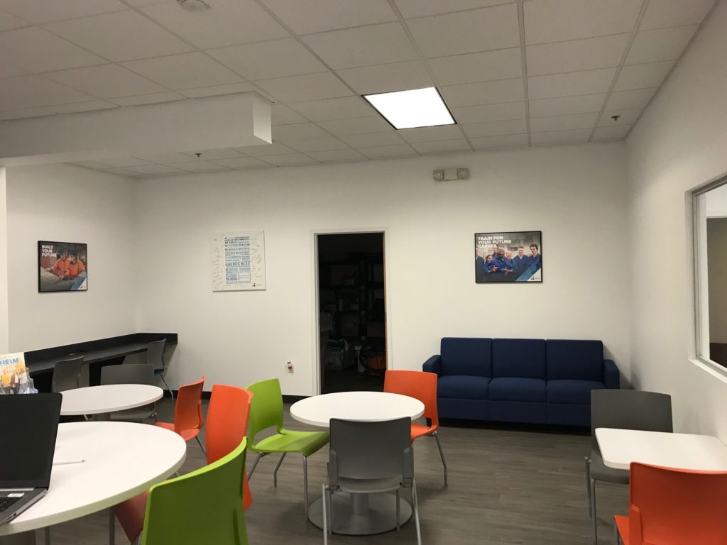 room with tables, chairs, and a blue couch at the Seminole Career Center 