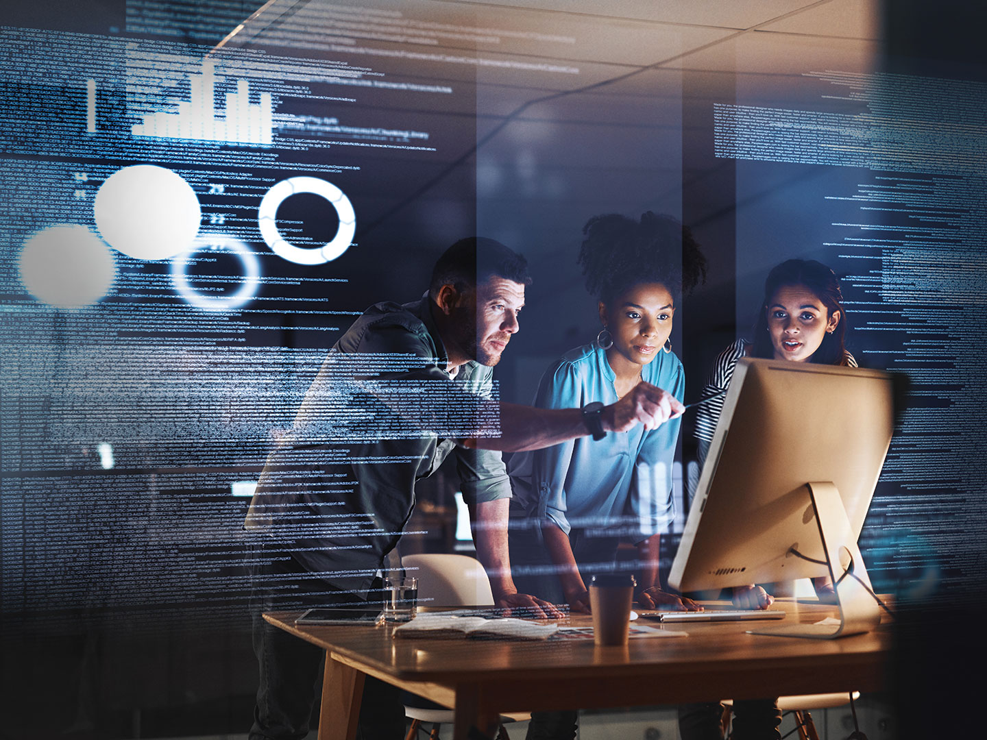 Information Technology professionals standing in front of a computer