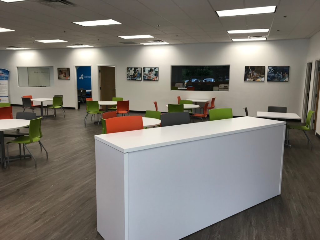 white desk with orange, grey, and green chairs behind it at the Seminole Career Center 