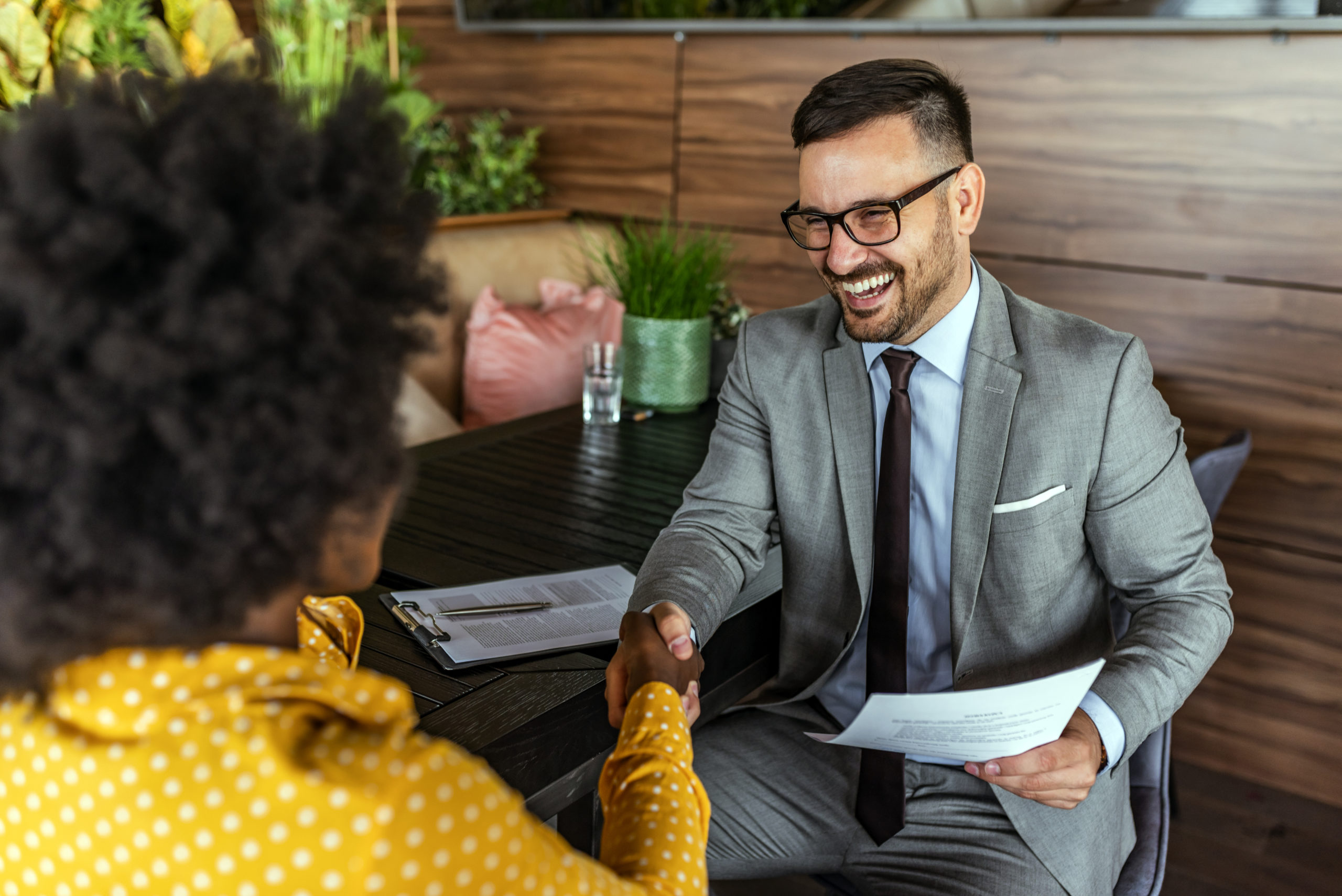 Male employer shaking new female employee's hand. Year End Updates 2020