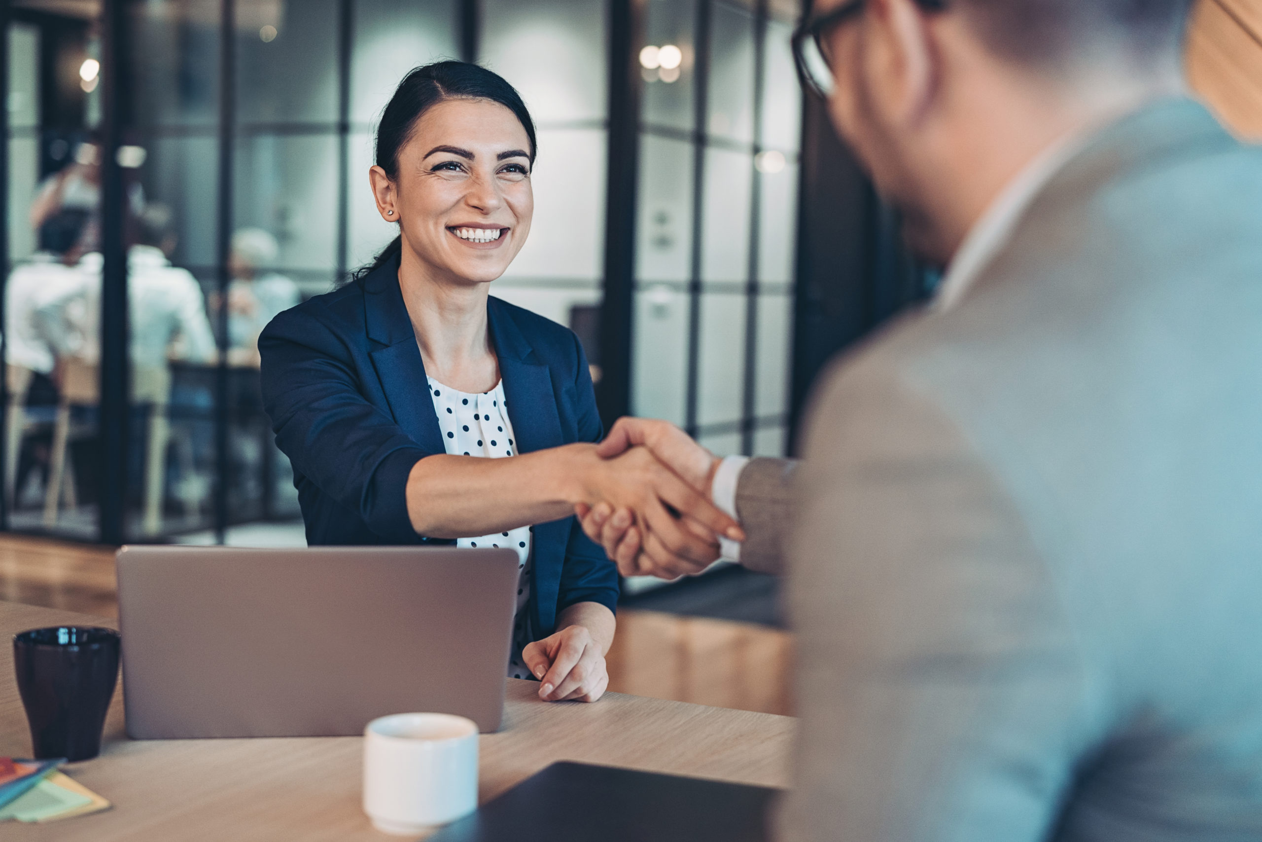 interviewee shaking interviewer's hand to introduce herself - this is an example of using an essential soft skills