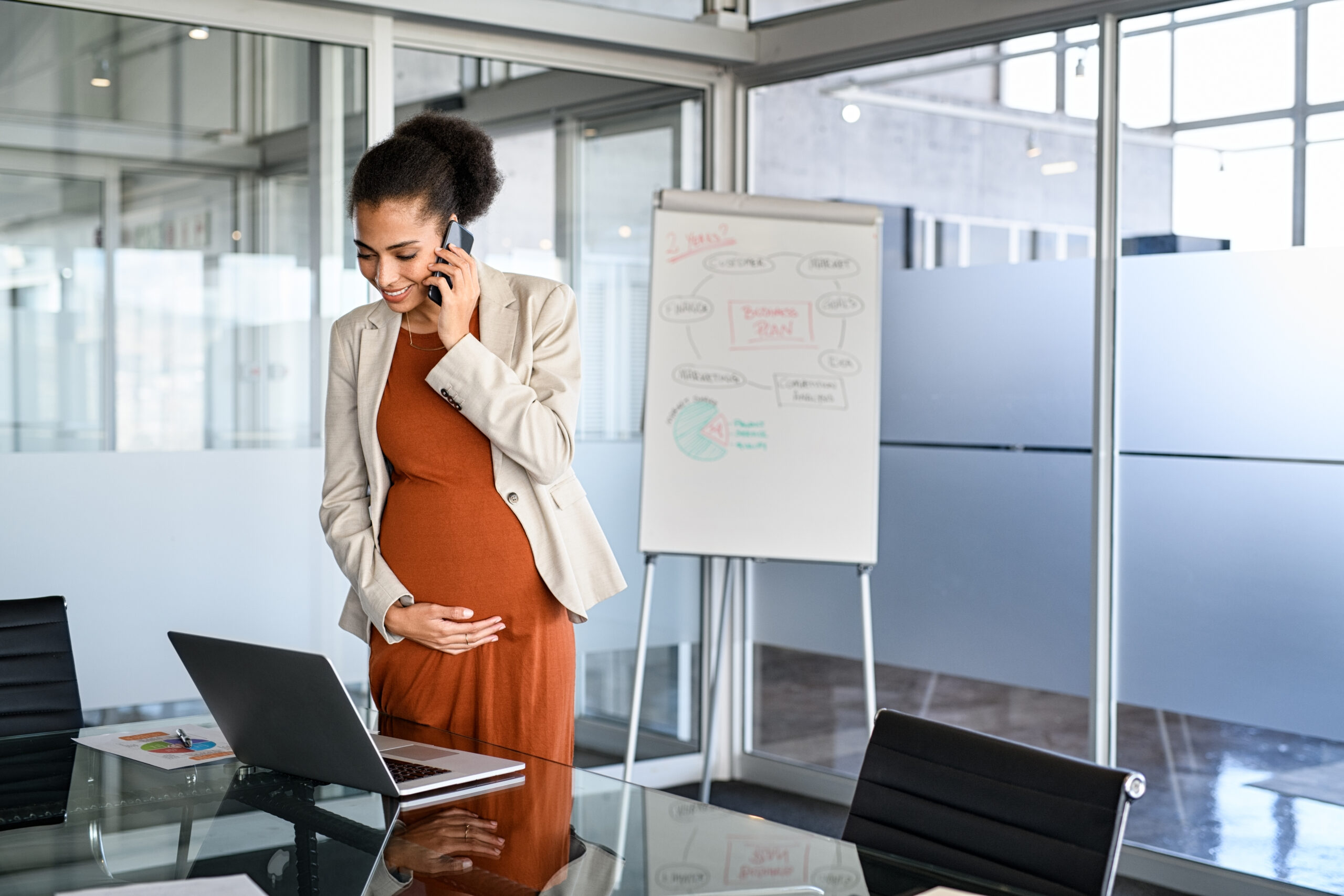 Pregnant black business woman working in office