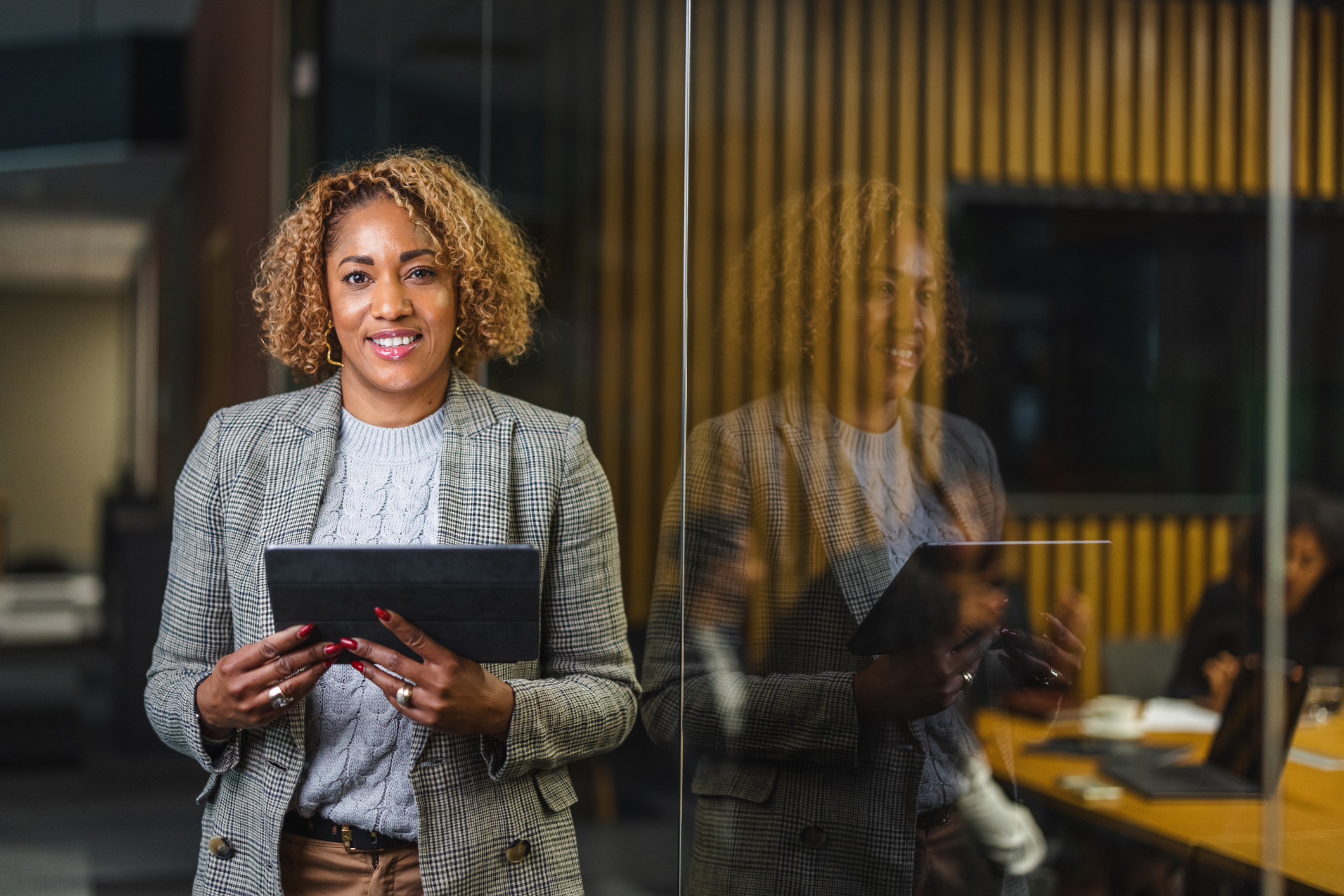 Photo of business woman holding a tablet outside of a meeting